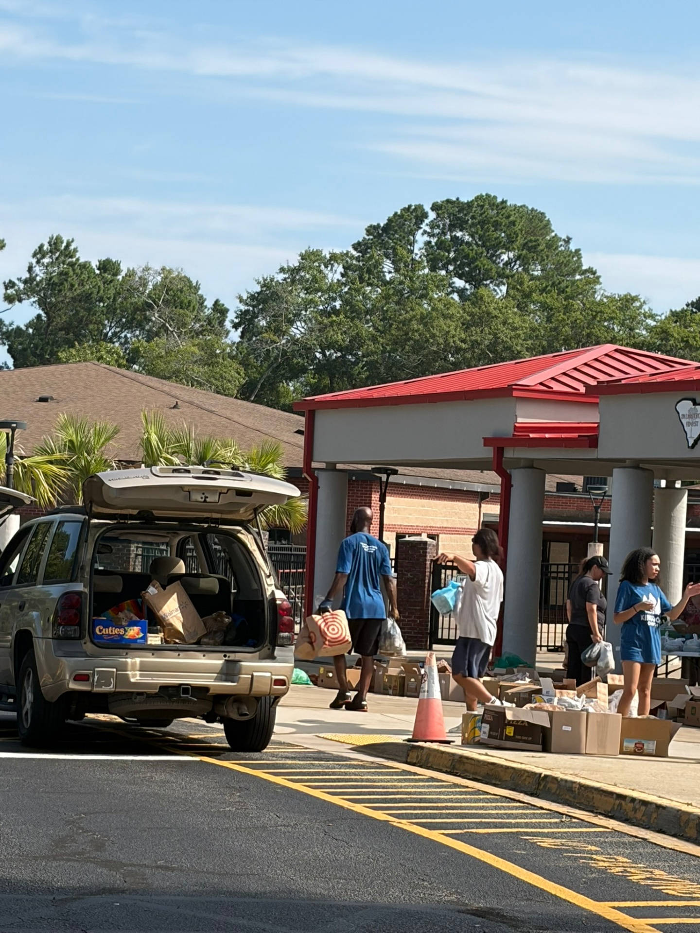 Volunteers loading prepared food packages during a local drive-through distribution effort.