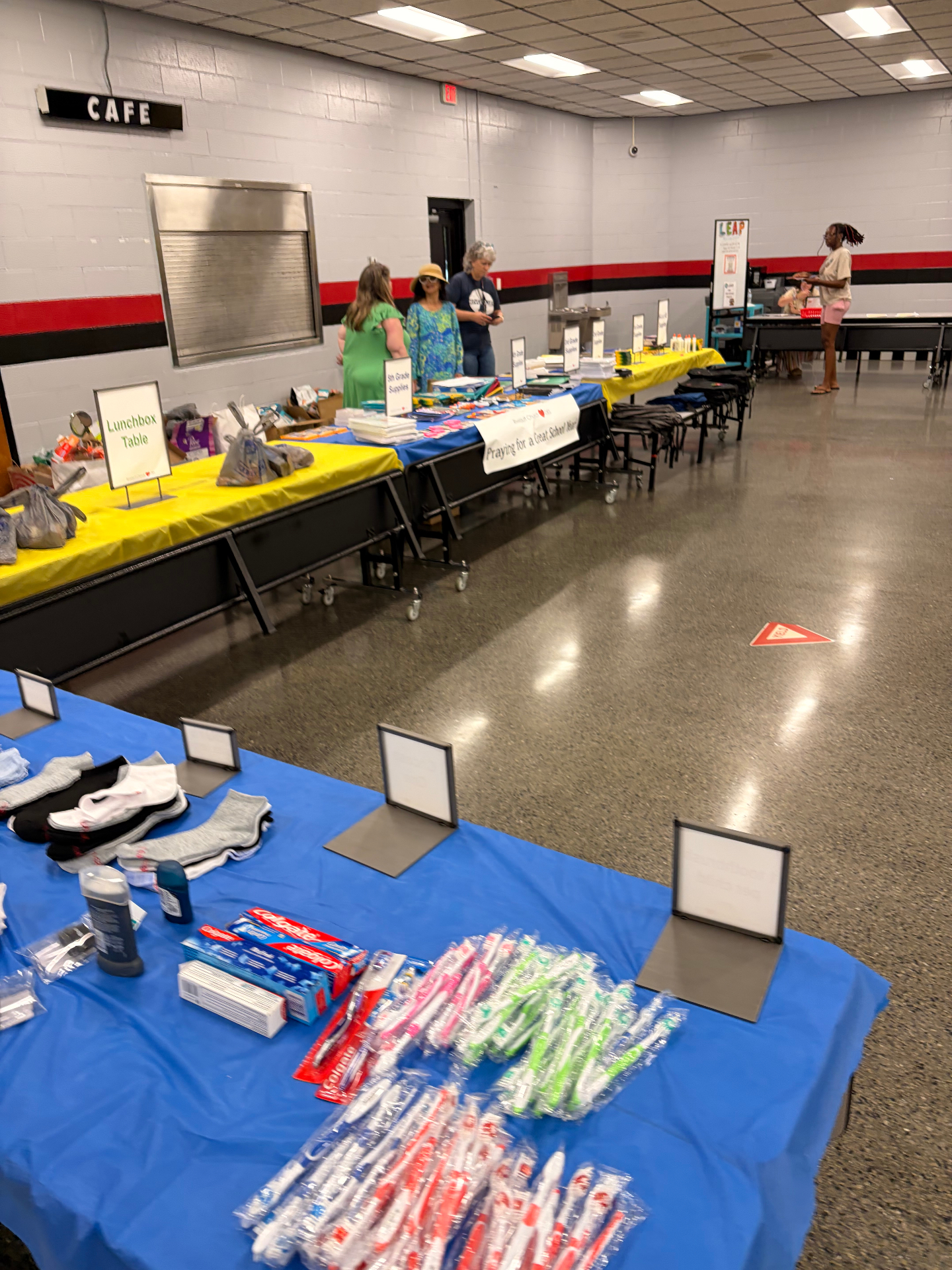 School supplies and hygiene products arranged on tables for students and families.