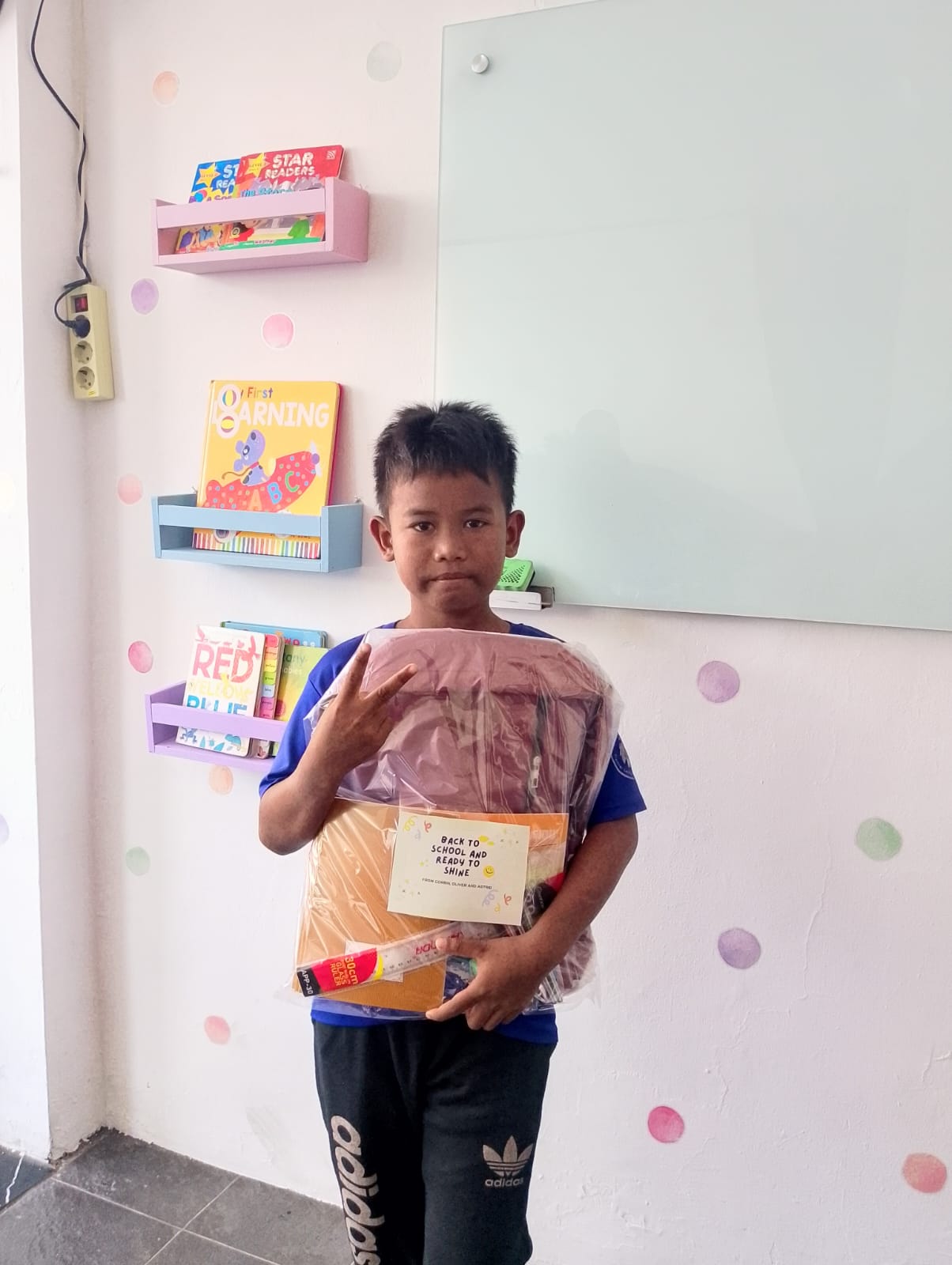 A student receiving a backpack and school supply kit.