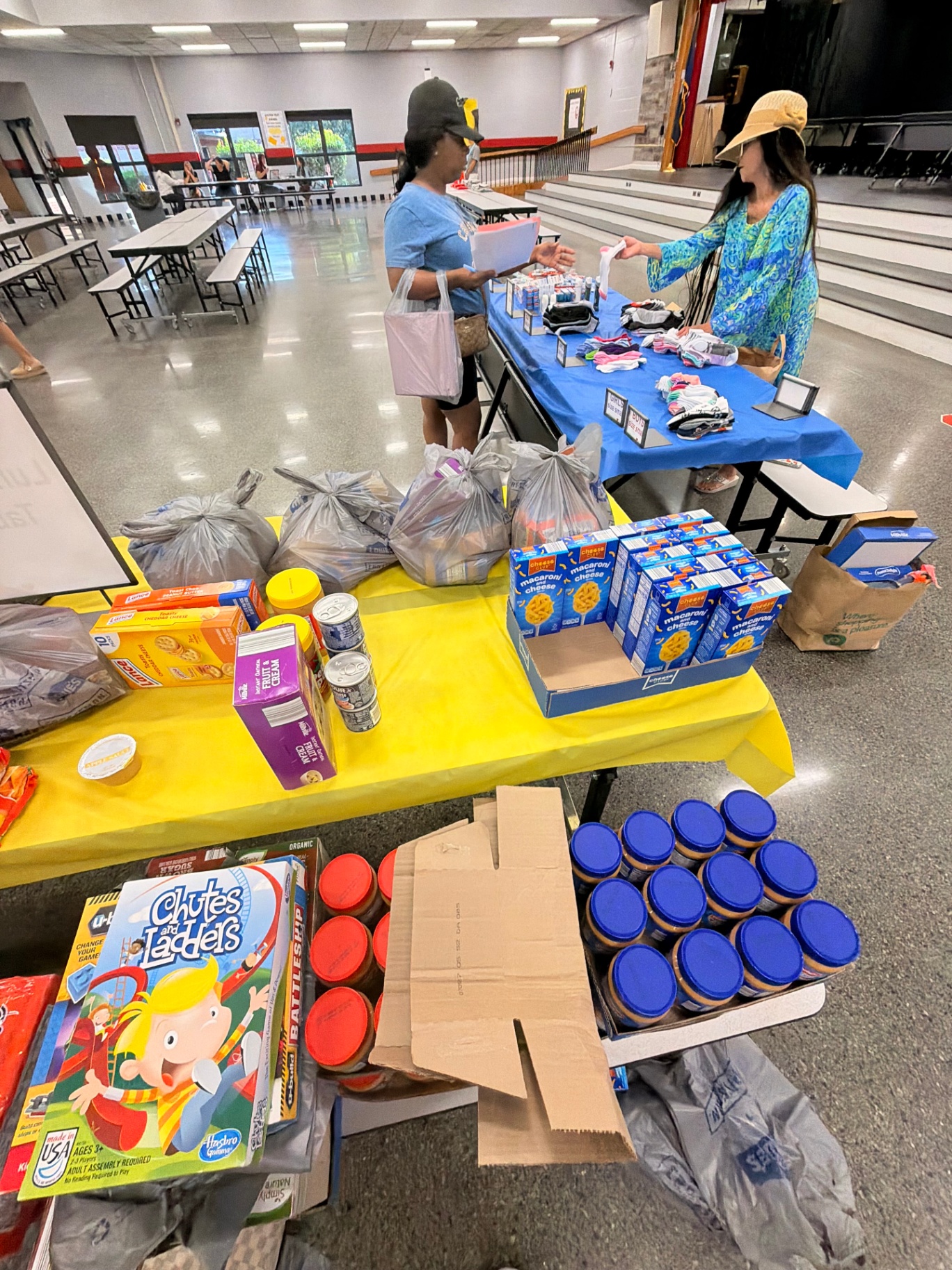 Volunteers assisting families at the socks and toiletries distribution table.
