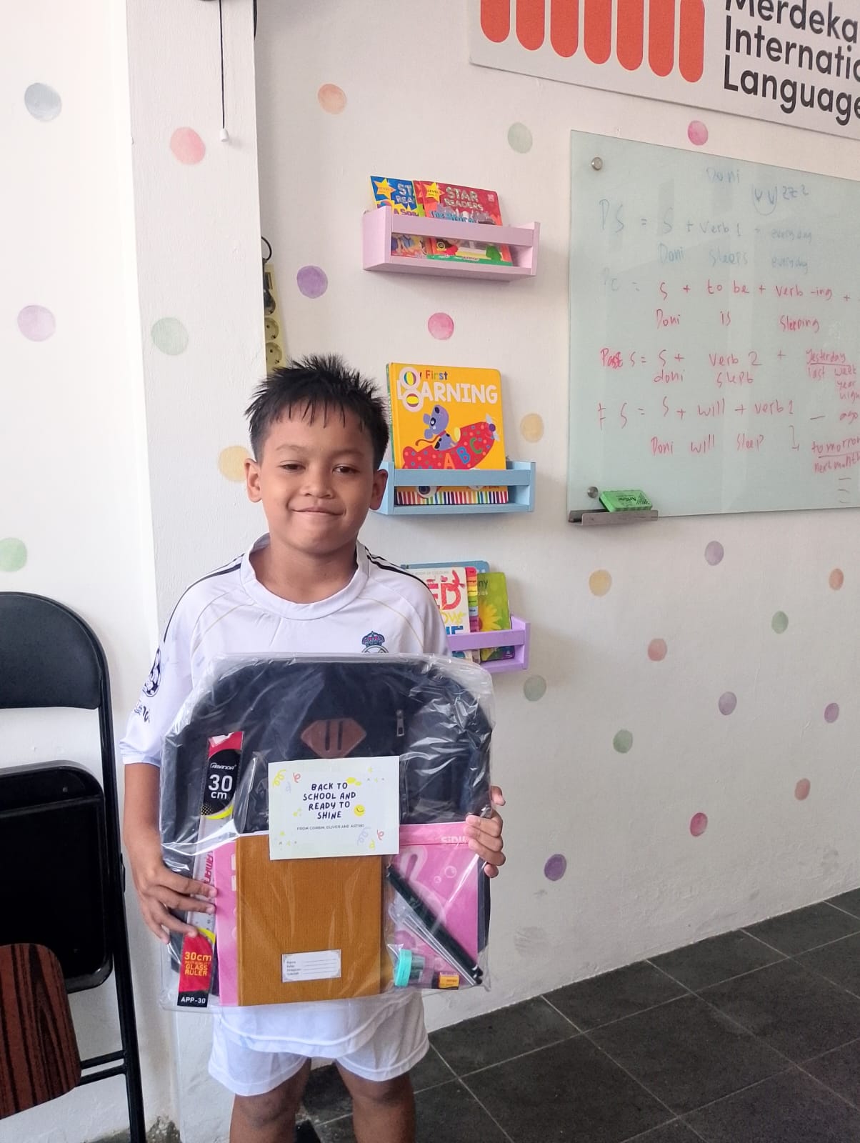 A young student with a new back-to-school supply kit.