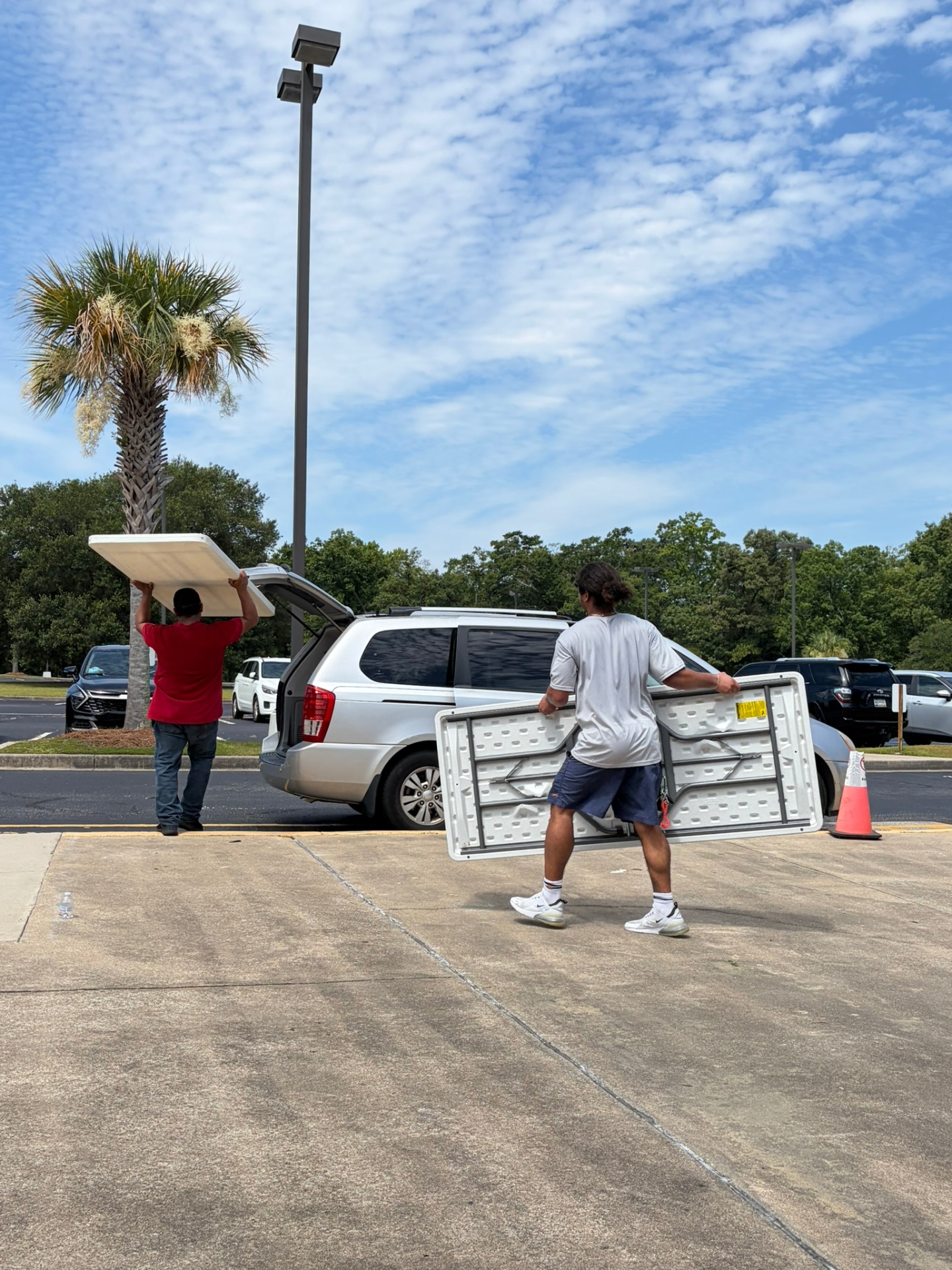 Volunteers moving folding tables during food distribution setup.